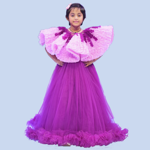 Young girl wearing a purple and pink dress with ruffled sleeves on a light blue background