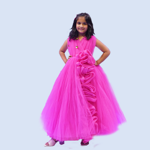 Young girl wearing a pink dress with a floral design on a light blue background  by fashion designers in pune