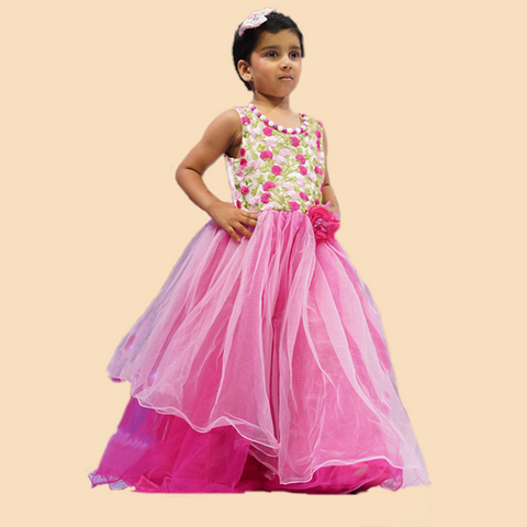 Young girl wearing a pink and floral dress on a beige background