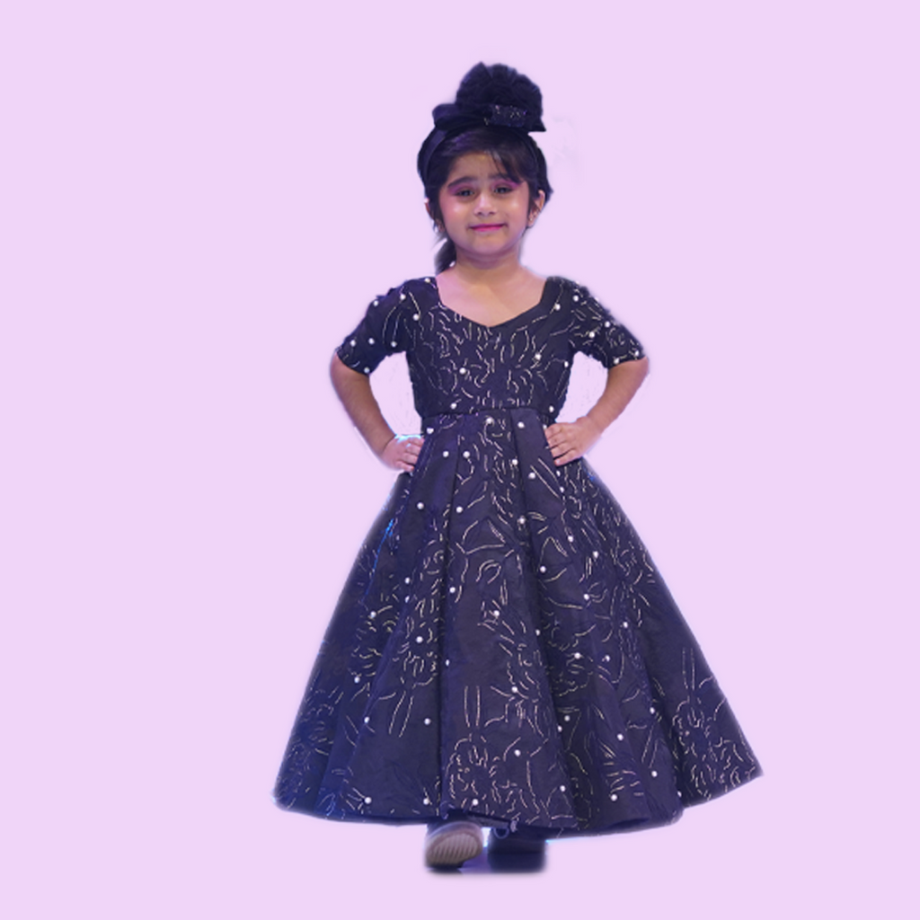 Young girl wearing a dark blue dress with star patterns on a light purple background 