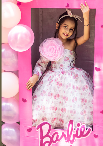 Young girl in a floral dress with pink balloons and 'Barbie' branding. - Fashion Designer in Pune