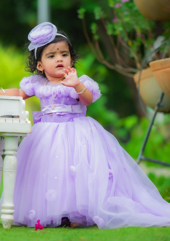 Child in a purple dress with a headband, standing outdoors by best fashion designers in pune
