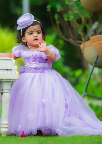 Child in a purple dress with a headband, standing outdoors by best fashion designers in pune