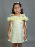 Young girl wearing a yellow dress with floral details against a gray background by fashion designer in pune