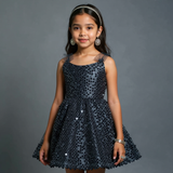 Young girl wearing a black sequin dress against a gray background    by aura fashionista