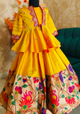 Yellow traditional outfit with floral patterns on a textured wall background by best fashion designer in pune