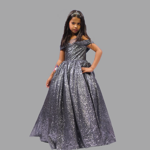 Young girl wearing a silver sequin dress on a gray background    by best fashion designer in pune